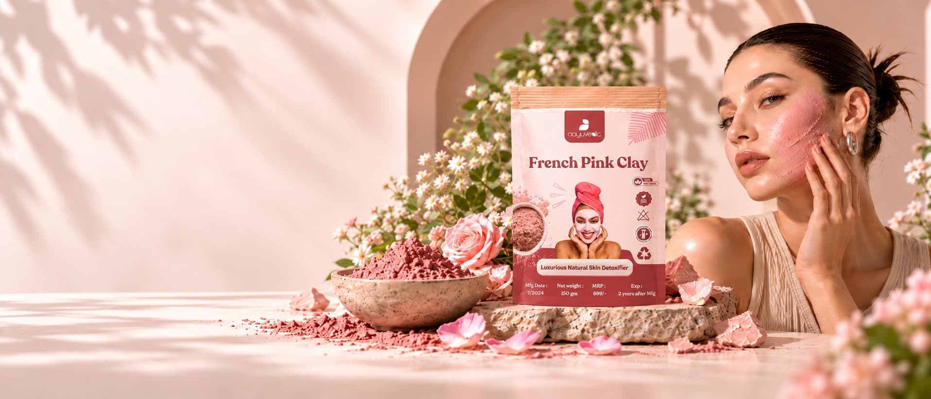 French Pink Clay pouch beside a bowl of mixed pink clay and fresh roses